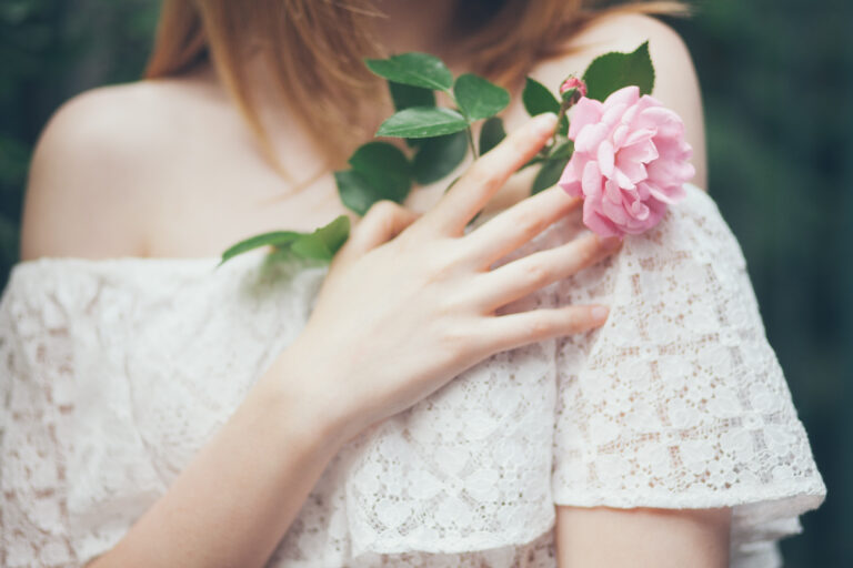 Girl,In,A,White,Dress,Holds,A,Rose,In,Her